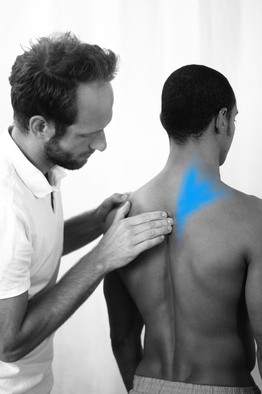 Osteopath Christoph Datler assessing the upper spine of an athlete with upper back pain, neck and shoulder discomfort